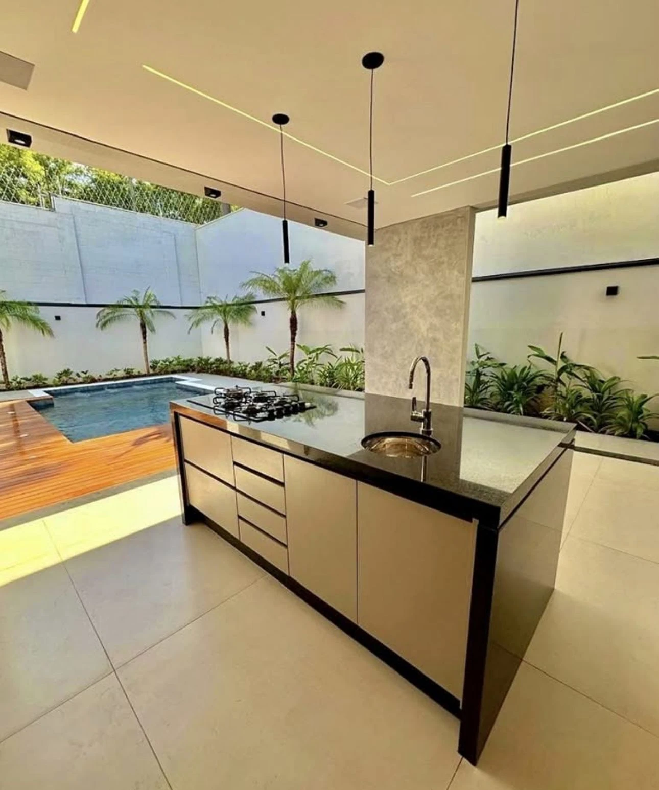 Área gourmet com pedra escura e vista para piscina